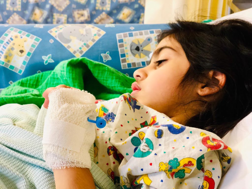Author's daughter lying in a hospital bed.