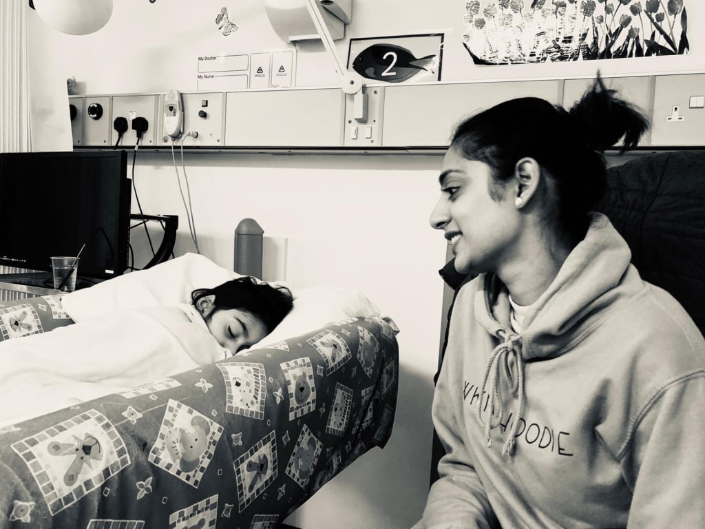 Author looking at her daughter who is recovering in a hospital bed